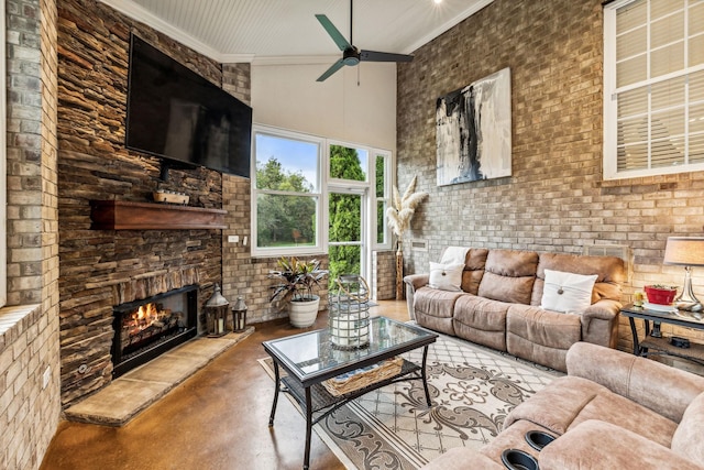 living room with concrete flooring, a large fireplace, ceiling fan, and a towering ceiling