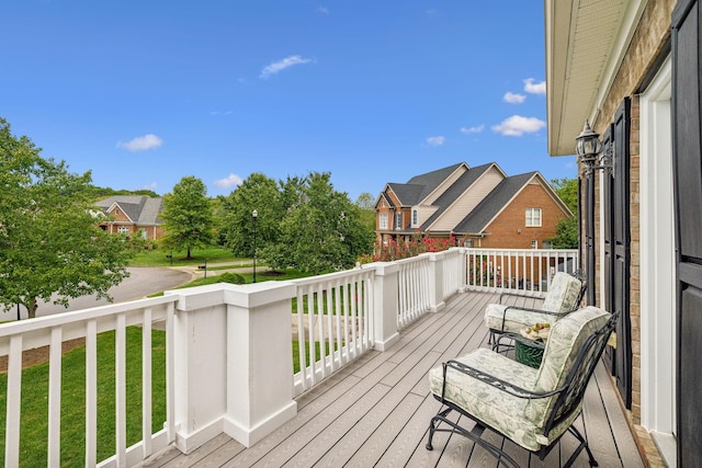 wooden terrace featuring a residential view and a lawn