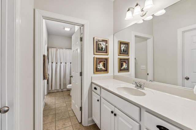 bathroom with toilet, vanity, and tile patterned floors