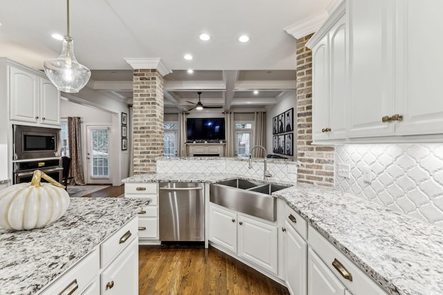 kitchen with decorative columns, stainless steel appliances, white cabinets, a sink, and coffered ceiling