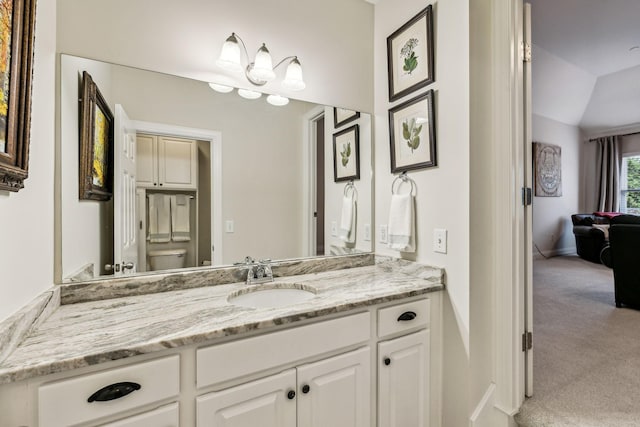 bathroom featuring vaulted ceiling, vanity, toilet, and baseboards