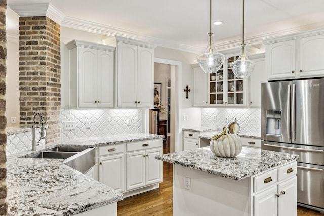 kitchen featuring a sink, a center island, white cabinets, and stainless steel fridge with ice dispenser