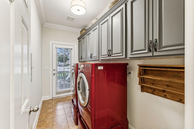 washroom featuring light tile patterned flooring, visible vents, cabinet space, washer and clothes dryer, and crown molding