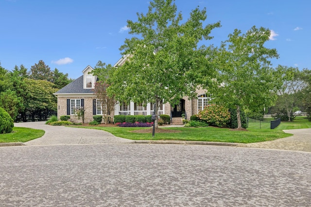 obstructed view of property with a front yard, fence, and driveway