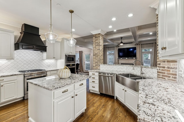 kitchen featuring stainless steel appliances, a sink, white cabinets, hanging light fixtures, and custom exhaust hood