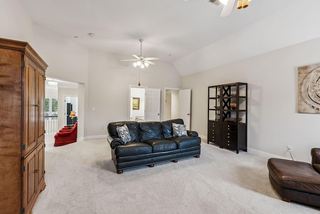 living area featuring light carpet, vaulted ceiling, and a ceiling fan