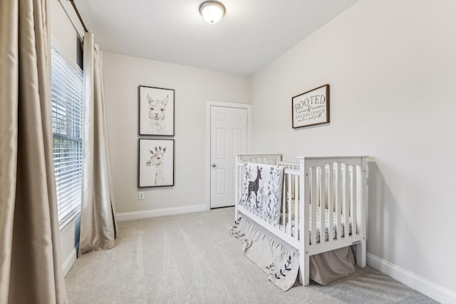 bedroom featuring light carpet, multiple windows, and baseboards