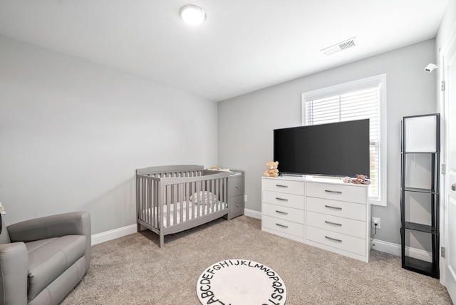 bedroom featuring baseboards, visible vents, and light colored carpet