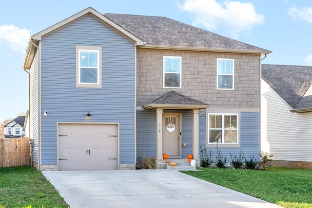 traditional home with entry steps, concrete driveway, a front yard, and a garage