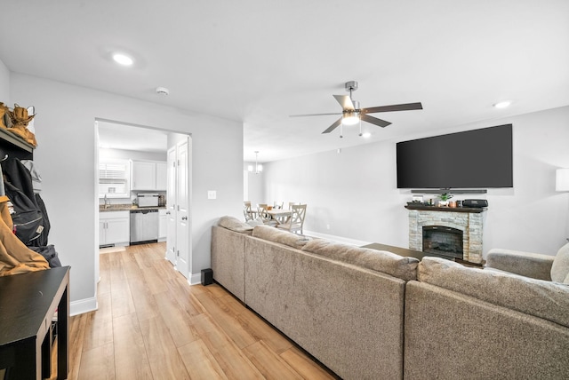 living room featuring a fireplace, recessed lighting, light wood-style flooring, ceiling fan, and baseboards