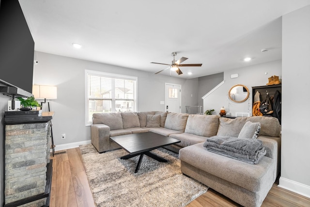 living room with light wood-type flooring, baseboards, and recessed lighting