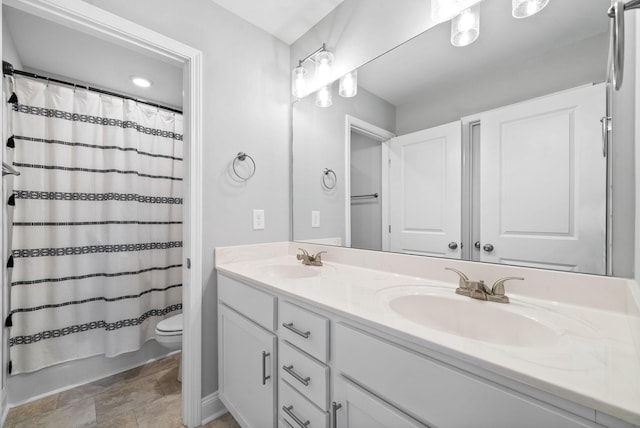 bathroom featuring double vanity, toilet, a sink, and shower / tub combo with curtain