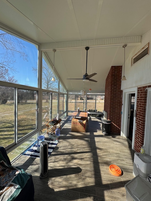 sunroom / solarium with lofted ceiling and a ceiling fan