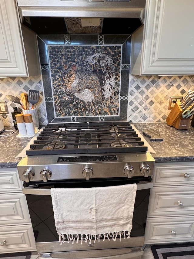 kitchen featuring stainless steel gas stove, wall chimney range hood, white cabinetry, and backsplash