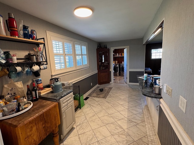 kitchen with marble finish floor, washing machine and dryer, and open shelves