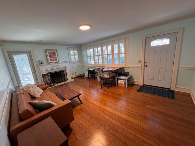 living room with a fireplace with flush hearth, light wood-type flooring, crown molding, and baseboards