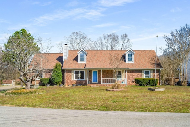 cape cod home with brick siding, covered porch, and a front lawn