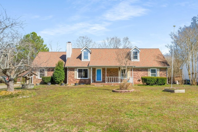 cape cod home with a front yard, brick siding, and a chimney