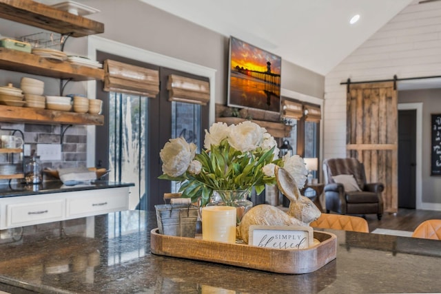 interior space featuring a barn door, high vaulted ceiling, wood finished floors, and recessed lighting