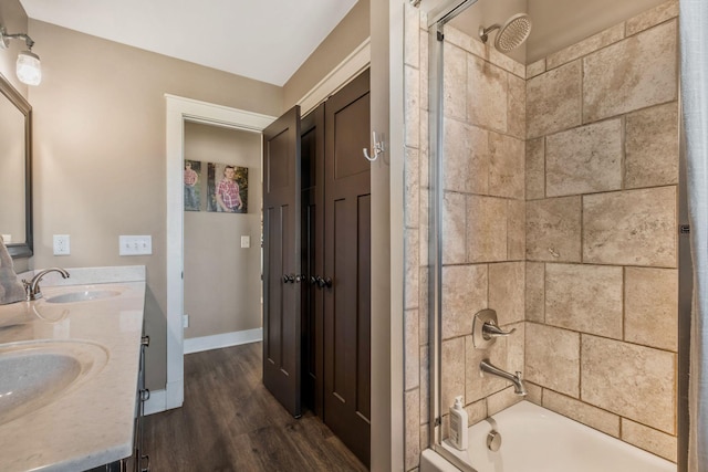 full bathroom featuring shower / bath combination, double vanity, a sink, and wood finished floors