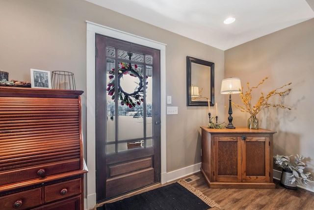 foyer with baseboards and dark wood-type flooring