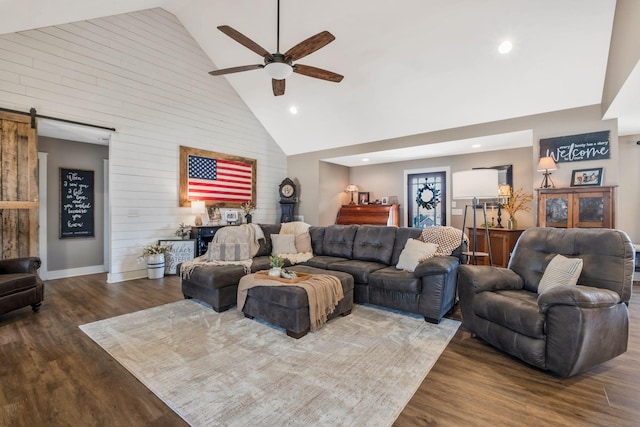 living area with recessed lighting, a barn door, ceiling fan, wood finished floors, and high vaulted ceiling