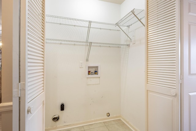 laundry area featuring washer hookup, light tile patterned floors, electric dryer hookup, laundry area, and baseboards