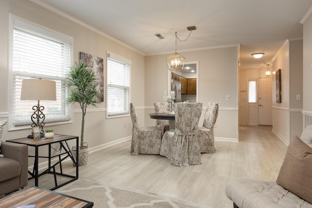 dining space with a chandelier, visible vents, light wood-style floors, and ornamental molding