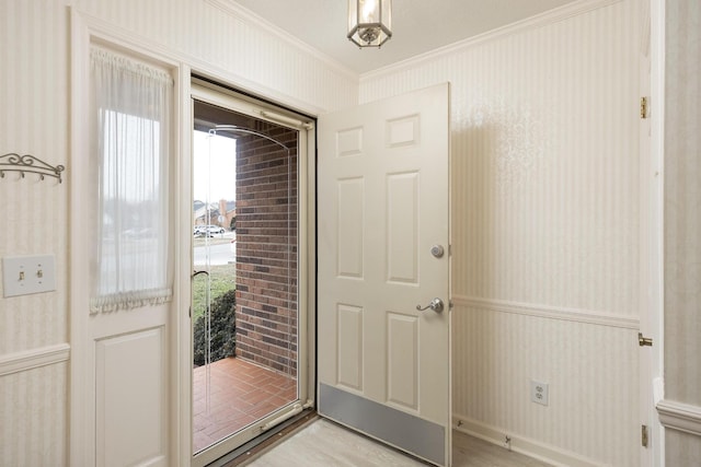 entrance foyer with crown molding, light wood finished floors, and wallpapered walls