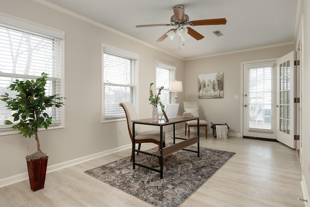 home office featuring light wood-style floors, plenty of natural light, visible vents, and crown molding