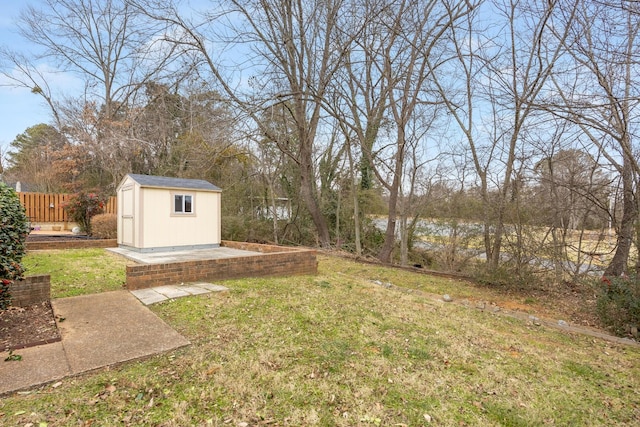 view of yard featuring a storage unit, an outdoor structure, and fence