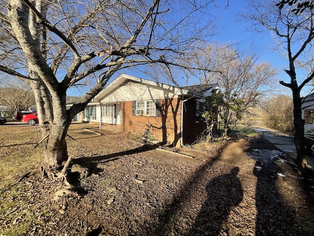 view of property exterior featuring driveway and brick siding