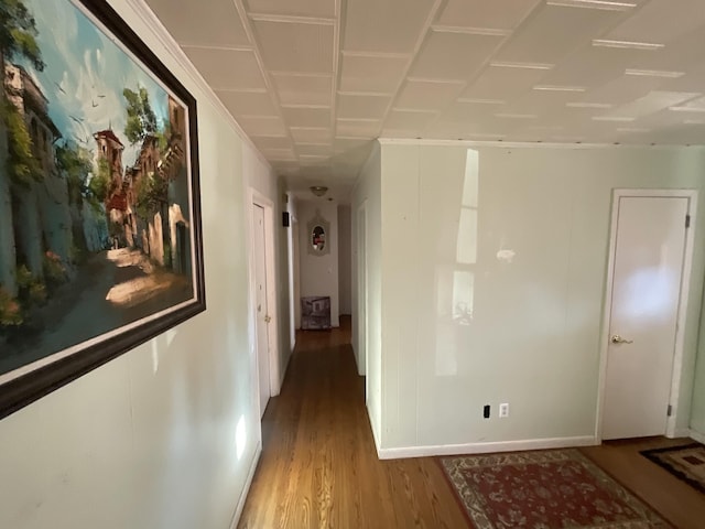 hallway featuring baseboards and wood finished floors