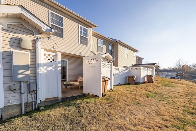 rear view of house featuring a yard and fence