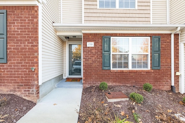 doorway to property featuring brick siding