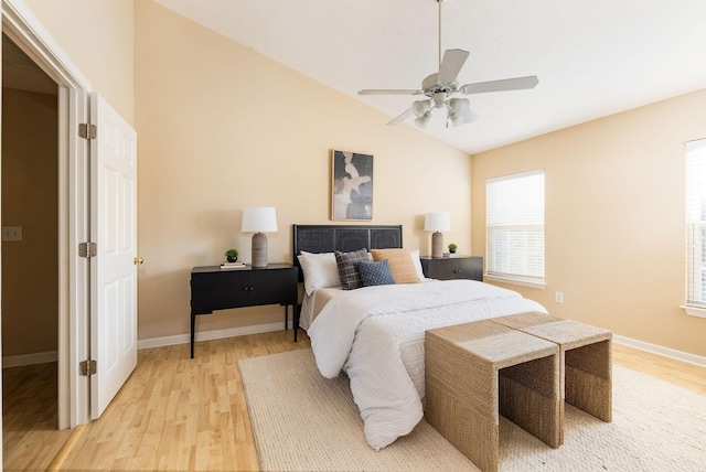 bedroom featuring a ceiling fan, lofted ceiling, baseboards, and light wood finished floors