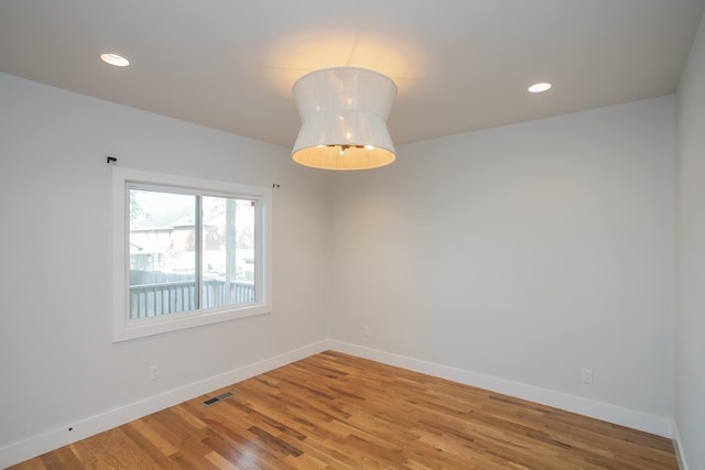 spare room with visible vents, baseboards, wood finished floors, and recessed lighting