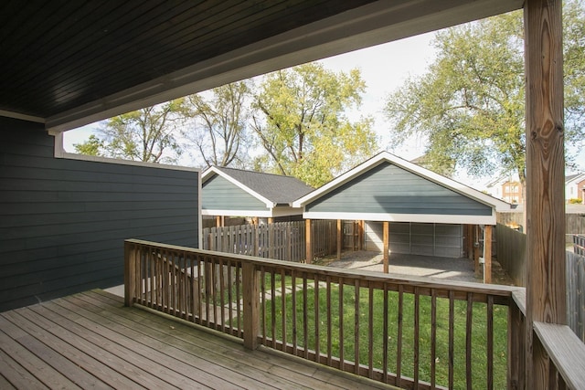 deck featuring a garage, fence, and a lawn