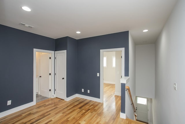 spare room featuring recessed lighting, wood finished floors, visible vents, and baseboards