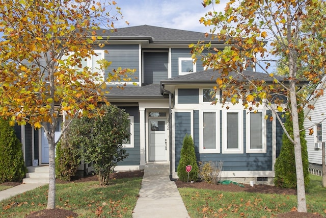 view of front facade with a shingled roof and crawl space