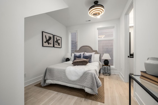 bedroom with baseboards, visible vents, and light wood-style floors