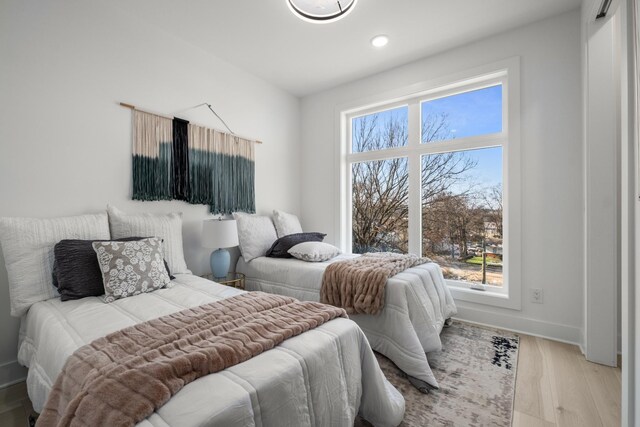 bedroom with light wood finished floors and baseboards