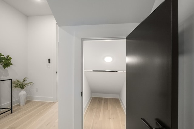 hallway featuring light wood-style flooring and baseboards