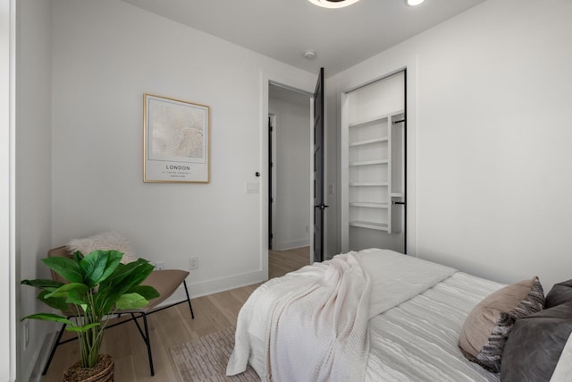 bedroom with a closet, baseboards, and wood finished floors