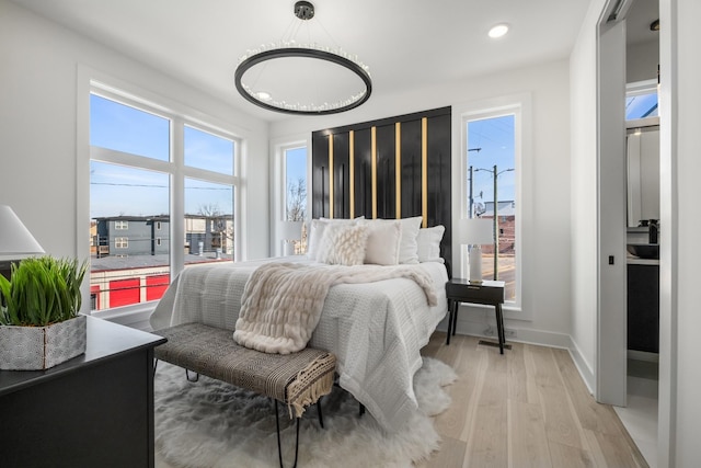 bedroom with multiple windows, baseboards, wood finished floors, and recessed lighting