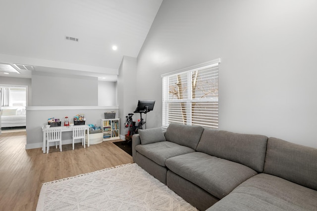 living area featuring high vaulted ceiling, visible vents, wood finished floors, and recessed lighting