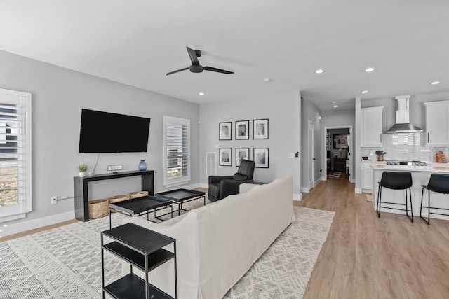 living room featuring light wood finished floors, recessed lighting, a wealth of natural light, and a ceiling fan