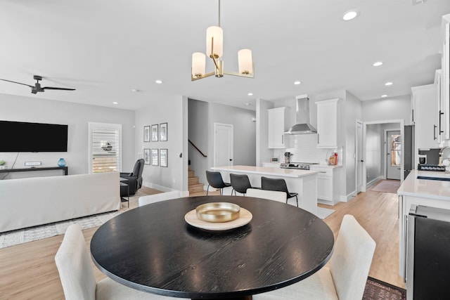 dining room featuring stairs, light wood-type flooring, a chandelier, and recessed lighting