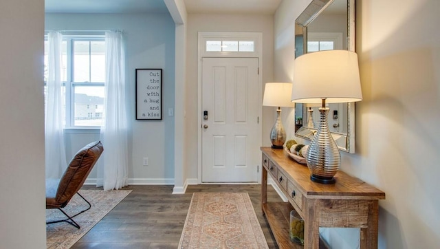 foyer entrance with dark wood-type flooring and baseboards