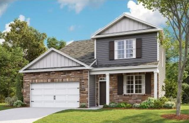 traditional home with a garage, concrete driveway, board and batten siding, and a front yard